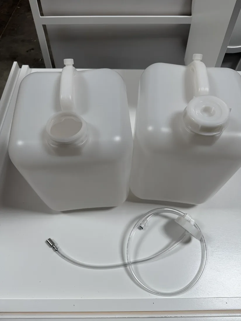 Two water jugs and the connecting tubing from the RidgeCraft water jug kit